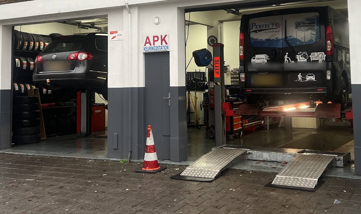 De twee werkplaatsbruggen van Eco-Tec Carcenter met een auto en een bestelbus omhoog, gezien vanaf de straat