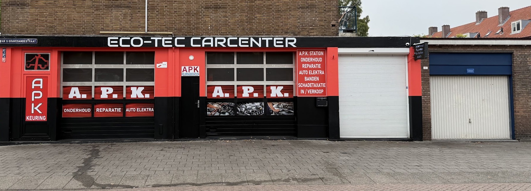 De volledige rood-zwarte voorgevel van Eco-Tec Carcenter met de naam op de zwarte band en de A.P.K.-panelen in de ramen